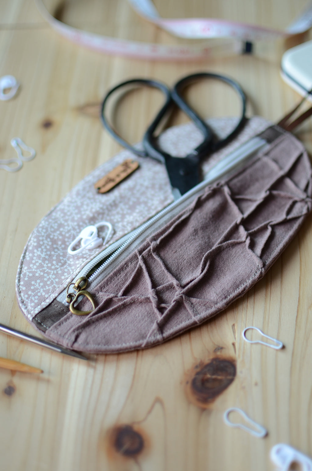 Unique knitting needle organizer for knitting needles, stitch markers, tape measure, and scissors