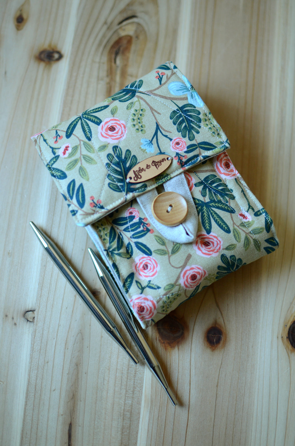 Interchangeable knitting needle storage with a zipper pocket