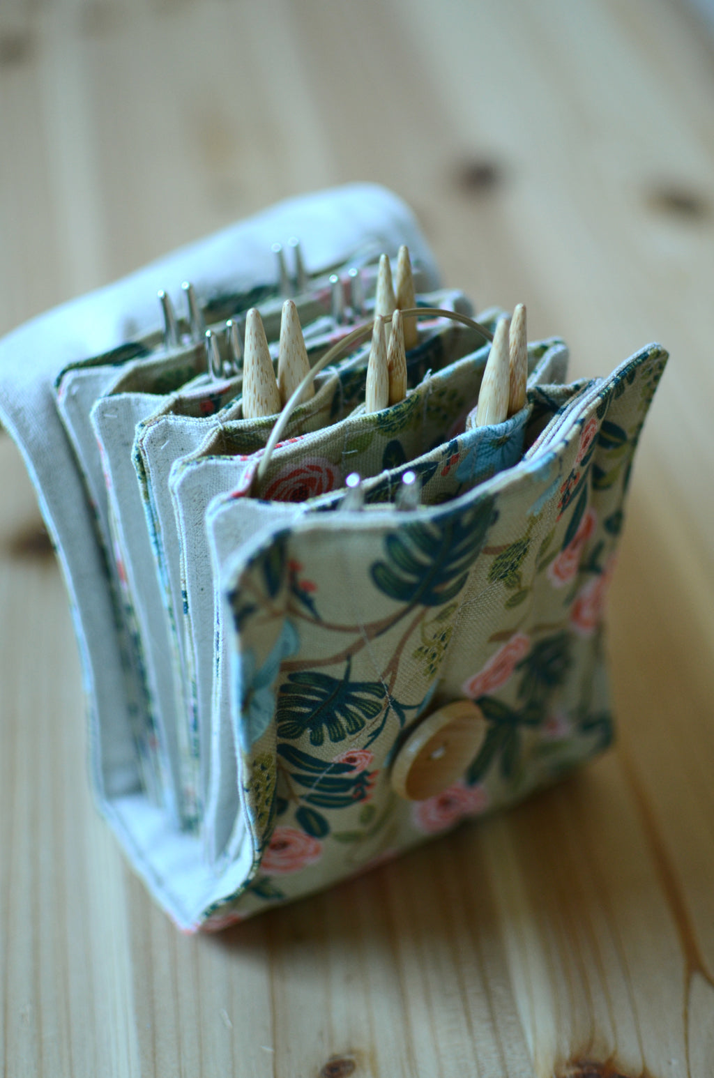 Interchangeable knitting needle storage with a zipper pocket