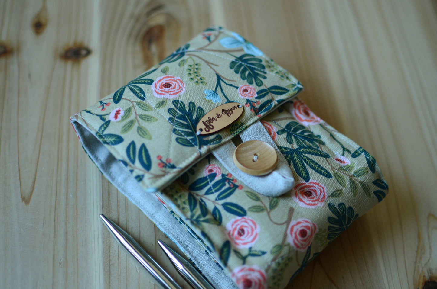 Interchangeable knitting needle storage with a zipper pocket