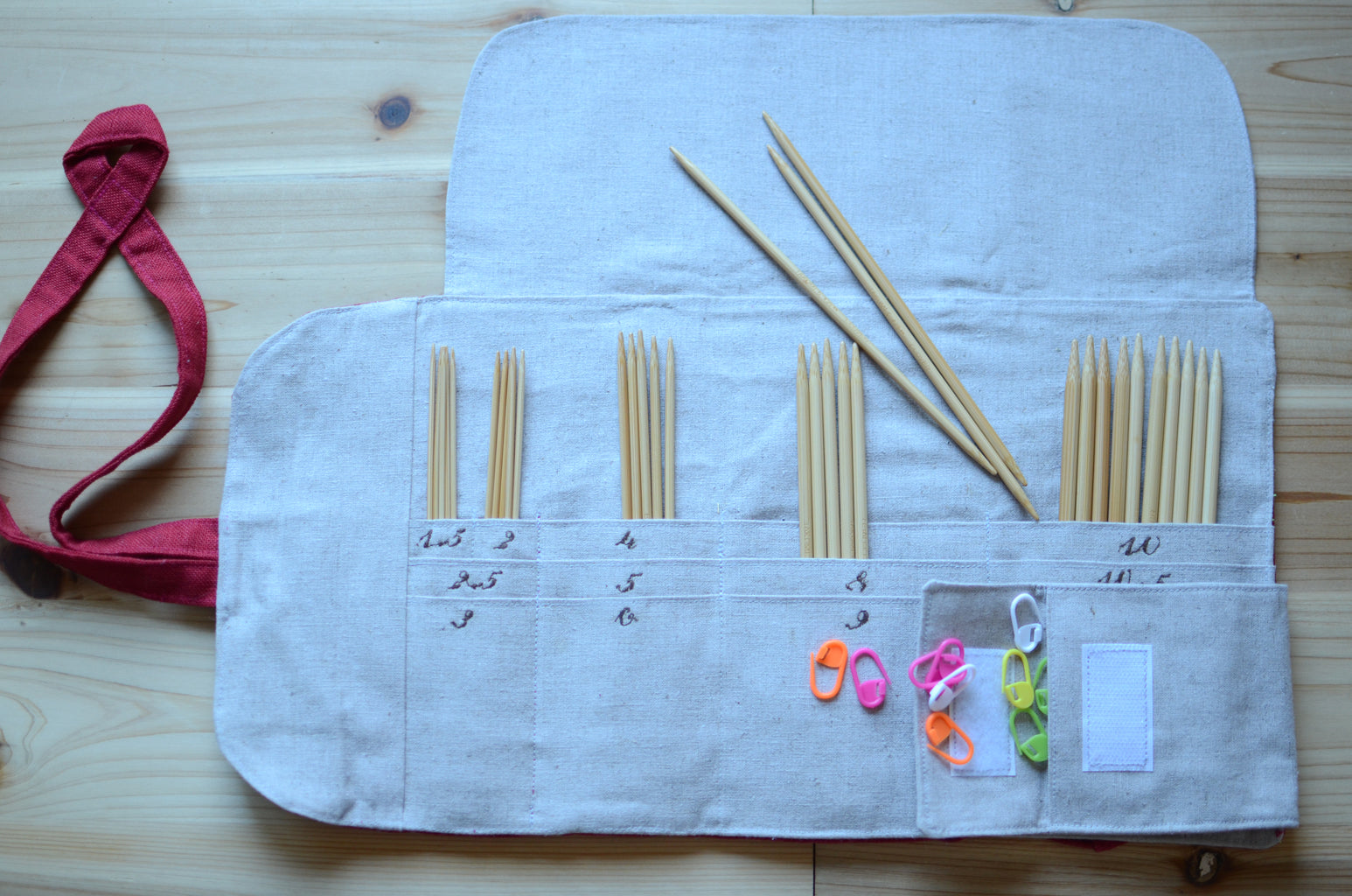 Interchangeable knitting needle storage with a zipper pocket