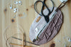 Unique knitting needle organizer for knitting needles, stitch markers, tape measure, and scissors